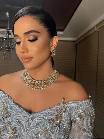 A sleek, side-parted low bun for a luxe and luminous look. This hairstyle is perfect for off-shoulder gowns, highlighting the neckline and jewelry.