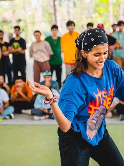 A dancer smiles as she grooves in the battle circle, surrounded by her supportive community.
