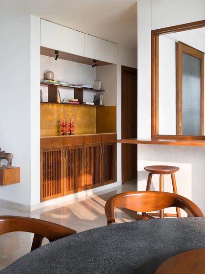 A custom storage alcove I designed, featuring teak cabinetry with brass hardware and a Jaisalmer stone countertop. I use natural materials to create rich, layered compositions even in small nooks.