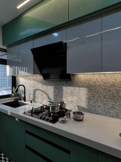 A closer look at the glossy cabinets and the detailed backsplash, showcasing the quality of materials and finishes.