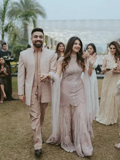 The couple's happy entrance into their Roka ceremony. This candid shot captures their excitement as they walk hand-in-hand, greeted by their loved ones.