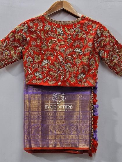 The back view of the red bridal-style blouse, showing the continuous, intricate embroidery.