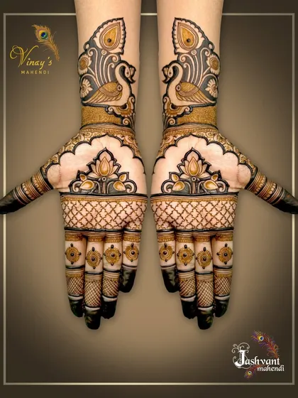A simple yet elegant symmetrical design with peacocks on the wrists and lotus motifs on the palms. The finger details add a touch of royalty.