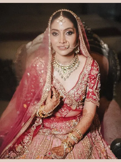 A classic, seated bridal portrait of Aditi. This shot captures her regal poise and the intricate details of her jewelry and makeup, making her look like a true maharani.