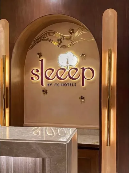 The illuminated brand signage for "Sleeep by ITC Hotels" set within a custom arched niche. The warm backlighting and intricate details reflect the high standards of this luxury hospitality brand.