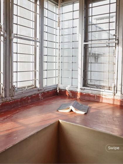 A sunlit corner reading nook, with a book left open. This image captures the quiet, intellectual spirit of the home, where every corner invites you to pause and read.