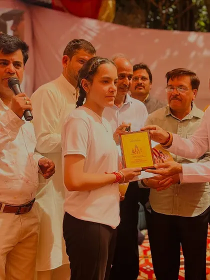 Another student being honored on stage for her dedication to the practice of yoga.