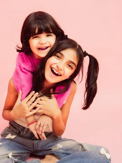 The pure, unfiltered joy of sisterhood. This studio kids photoshoot was all about capturing their vibrant energy and laughter against a simple, bright pink backdrop that lets their personalities shine.