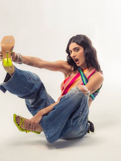 A playful, high-energy shot from a recent photoshoot. The bright neon heels and dynamic pose capture my personality perfectly.