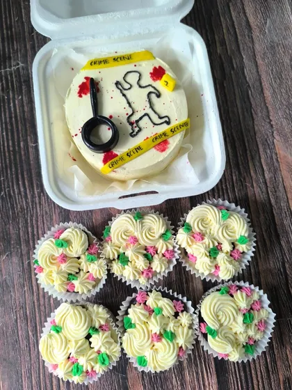 This forensic-themed bento cake and cupcake set was a blast to create for a true crime fan. The bento features edible crime scene tape and a magnifying glass, paired with floral cupcakes for a quirky combo.