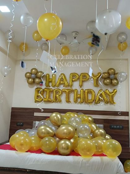 This view shows the gold flower-shaped balloon clusters on the wall, a small detail that adds a bit more design to the classic banner setup.