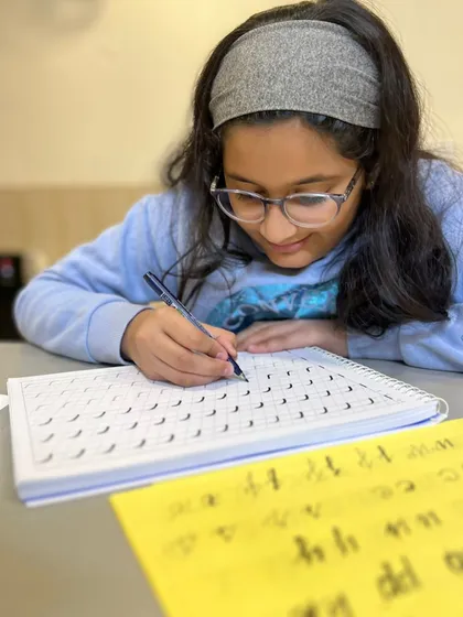 Practice, practice, practice! A student works on her handwriting and calligraphy drills. These exercises are key to developing muscle memory and creating beautiful, consistent letterforms.