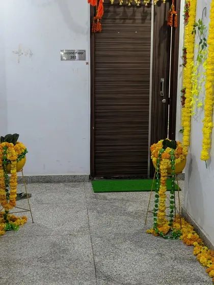 Simple and traditional entrance decor for a home pooja. I used marigold garlands on stands to create a welcoming path leading to the door.