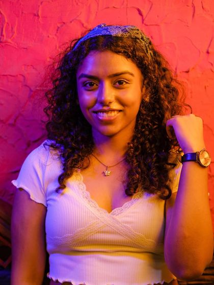 Another portrait from the MKT series, this time of a woman with curly hair smiling confidently at the camera. The blue and red lighting highlights her features and creates a dynamic feel.