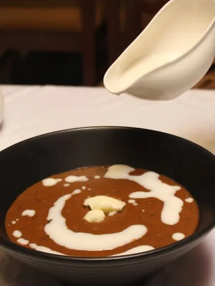 The final touch on our classic Dal Makhani. A swirl of fresh cream is added to the slow-cooked black lentils, giving it a rich, buttery finish that is simply irresistible.