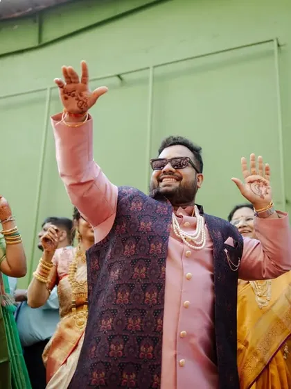 The groom dancing with his family and friends during the baraat, a moment of pure, uninhibited joy.