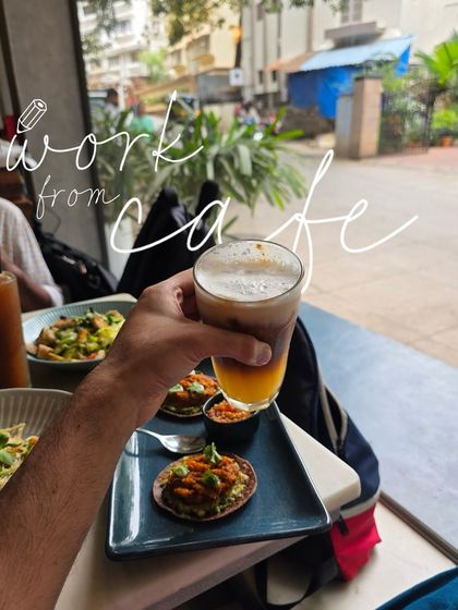 A 'work from cafe' moment, with a refreshing drink and tasty appetizers on the table.