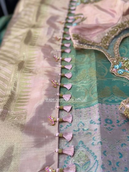 The back of this blouse is adorned with a line of delicate, custom-made tassels.