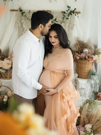 A tender embrace and a gentle kiss. This romantic couple's portrait captures the deep love and affection between the parents-to-be in a beautiful, soft-focus setting.