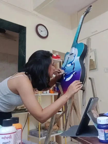 A shot of me working on a custom guitar. Painting on a curved wooden surface is a different challenge, but I love transforming instruments into unique pieces of art.