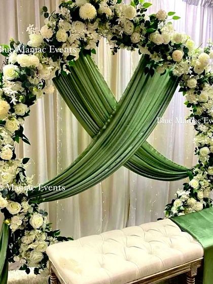 A beautiful Nikkah or engagement setup featuring a circular arch with white flowers and lush green draping. The design is clean, elegant, and perfectly suited for intimate ceremonies, providing a serene backdrop for the couple.