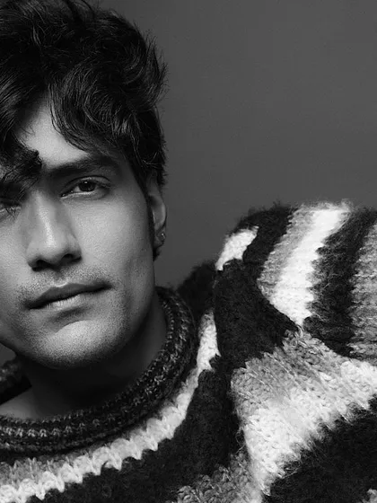 The same look in black and white, which emphasizes the texture of the sweater and the model's features. The clean grooming translates beautifully to monochrome.