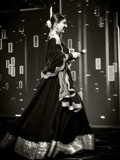 A black and white shot of me walking across the stage, mic in hand. It captures the motion and dynamic nature of my work as a live event host.