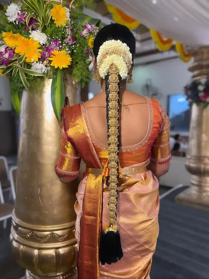 The beauty of a South Indian bride is in the details. This is a close-up of a traditional bridal hairstyle, featuring an intricate Jadde Bangara (hair jewellery) set against a classic braid and fresh jasmine flowers. I ensure every element, from the hair to the flowers, is perfectly placed and secure for the entire ceremony.