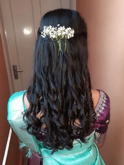 Soft, natural-looking curls adorned with a simple sprig of baby's breath. This hairstyle is effortlessly romantic and chic.