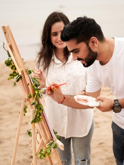 A fun and creative beach announcement shoot, where the couple paints a "Coming Soon" sign together.