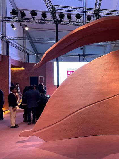 A repeat of image 9, showing a visitor dwarfed by the scale of the 'Terra' installation's abstract leaf forms.