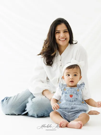 A beautiful seated portrait of this mother and child. The baby's curious expression and the mother's gentle smile make for a heartwarming image.
