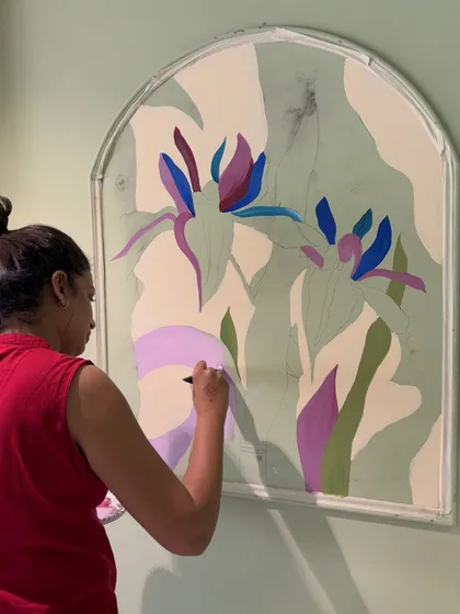 A work-in-progress shot of me painting one of the arched floral panels for a restaurant. This shows the layering of colors to build up the stylized forms of the flowers.
