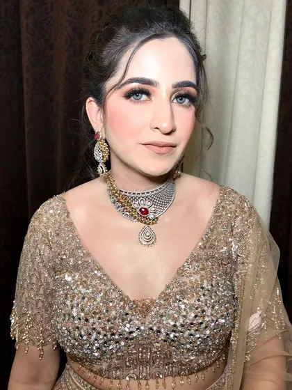This client is ready for her engagement party in a golden lehenga, styled with a two-toned diamond and ruby choker.