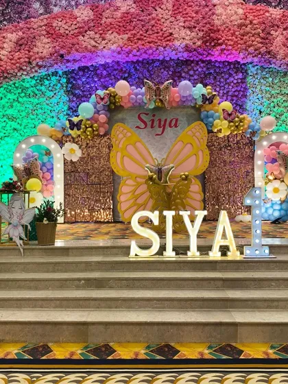 This grand butterfly-themed stage is perfect for a first birthday party. I designed this entire setup with a large sequin backdrop, a huge butterfly cutout, marquee letters for the name, and a colorful balloon arch to create a magical photo corner.