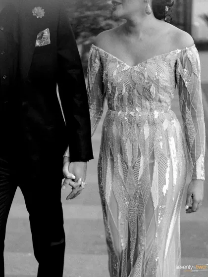 A black and white shot of the couple walking hand-in-hand, a simple and elegant depiction of the start of their journey together.