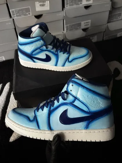 A pair of Nike Air Jordan 1 Mids with a cool blue cartoon effect, using different shades to create depth.