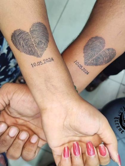 Another view of the unique fingerprint couple's tattoo, showing how the two pieces look when brought together. This design is a testament to a shared identity and love.