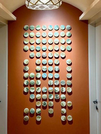 This installation features 100 hand-painted miniature landscapes on small, round canvases. It was commissioned for a long hallway in a Mumbai residence, turning it into a stunning gallery wall.