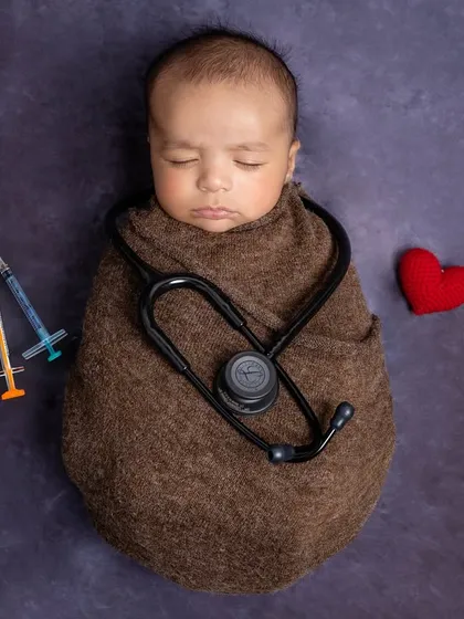 Born with a stethoscope in hand, just like mumma prescribed. This future doctor is wrapped warmly, surrounded by props that tell a personal family story.