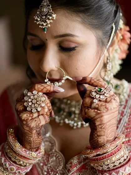 It's all in the details. This artistic shot captures the delicate balance of soft glam makeup, intricate henna, and traditional jewelry, creating a look that is both timeless and personal. ✨