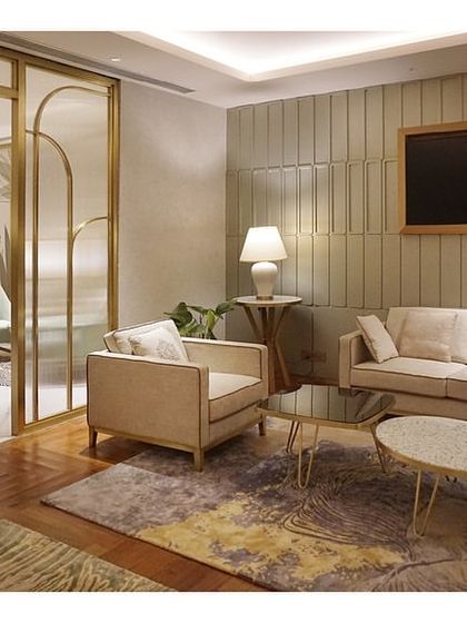 Another view of the Private Lounge at the Bangalore airport, showing the combination of beige sofas, textured rugs, and warm wood paneling. The design creates a serene and upscale environment for premium travelers.