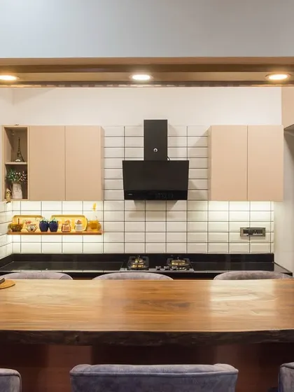 A similar pass-through design, this one feels more integrated with the living space, with comfortable bar chairs and a clean, modern aesthetic.