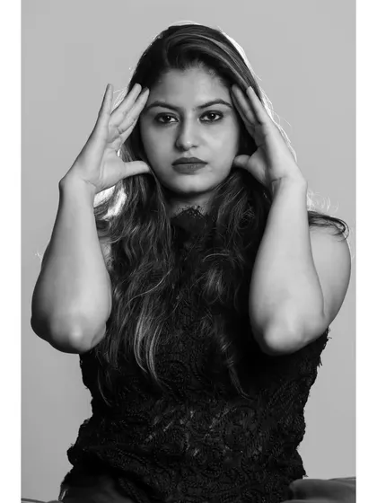 A dramatic pose with hands framing the face. This black and white shot emphasizes form and emotion.