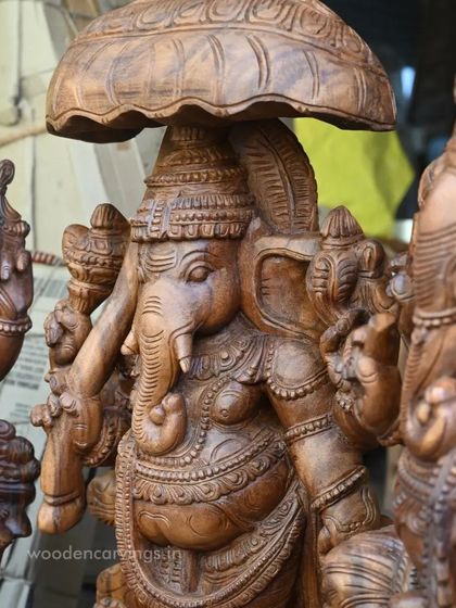 A close-up of the umbrella Ganesha from our workshop collection, detailing the carving on the umbrella itself.
