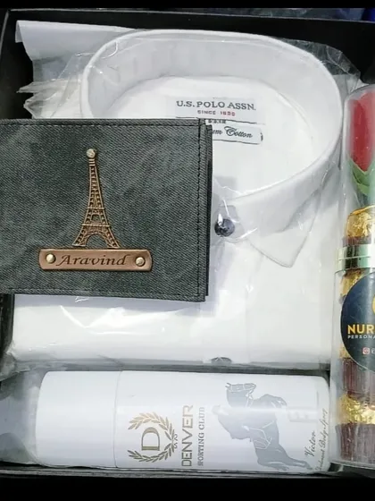 A perfect Valentine's gift hamper with a personalized wallet, a white shirt, deodorant, and a tube of Ferrero Rocher chocolates with a rose.
