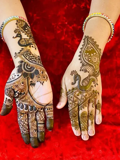 An elegant design featuring majestic peacocks. One hand has a bold, modern peacock, while the other has a more traditional, intricate version, showing versatility in a single theme.