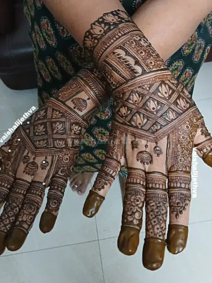 A beautiful back-hand design with intricate details. This pattern combines checks, floral elements, and hanging jhumkas for a rich and festive look.