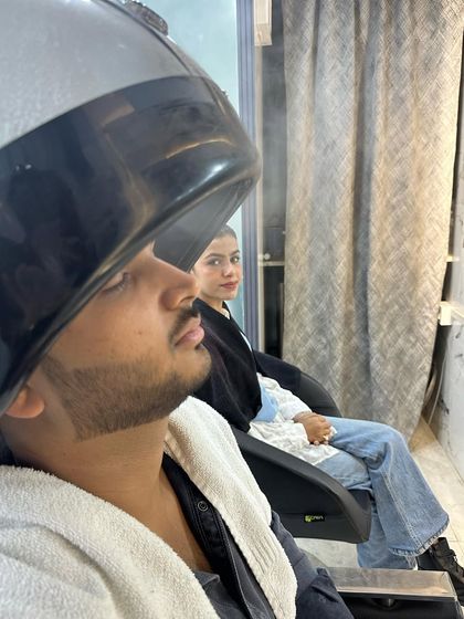 A client relaxing during a steam treatment as part of our men's hair spa. The steam helps to open up the hair cuticles, allowing the nourishing treatment to penetrate deeply for maximum hydration and repair.