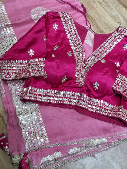 Another beautiful example of our custom blouse work. This pink blouse with detailed mirror work is paired with a matching saree, creating a complete and gorgeous wedding-ready outfit.
